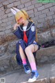 A woman in a school uniform sitting on some steps.